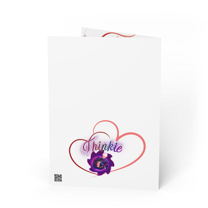 Folded greeting card with "Thinkie" logo inside red heart outline.